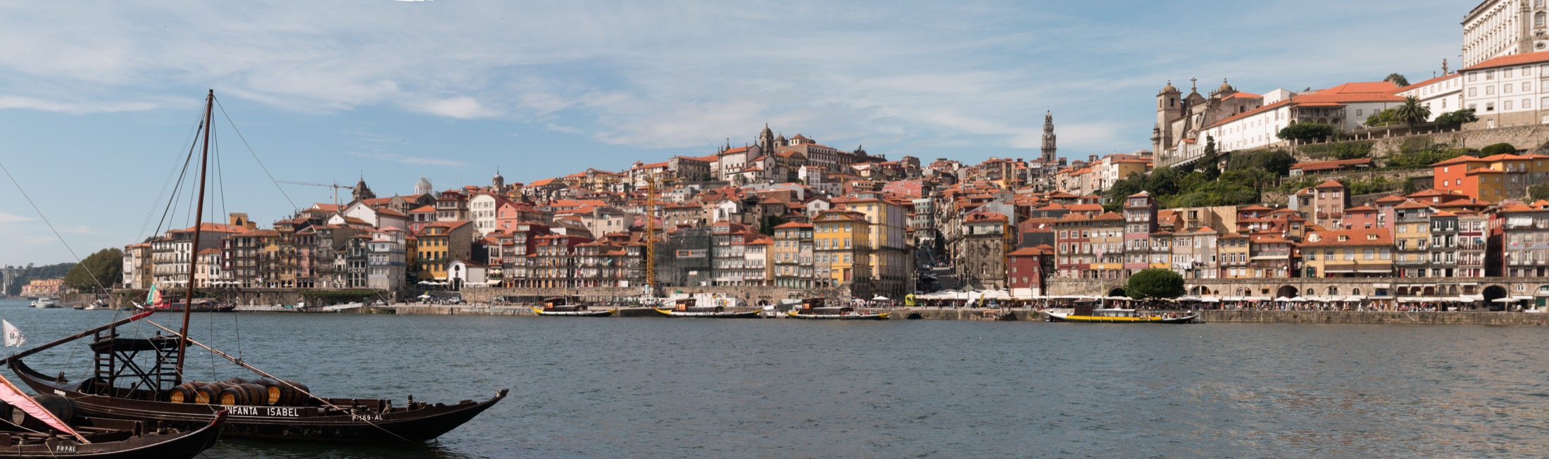 Les façades de Ribeira au bord du Douro à Porto, avec des bateaux rabelos au premier plan.